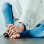 A person sitting on the ground with their feet crossed.