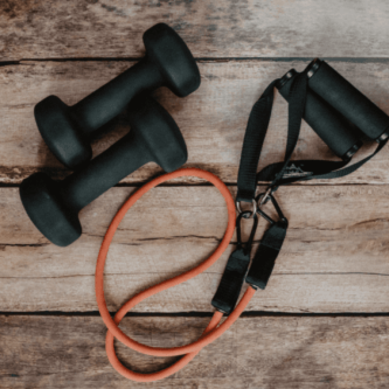 A pair of dumbbells and a jump rope on top of a wooden floor.